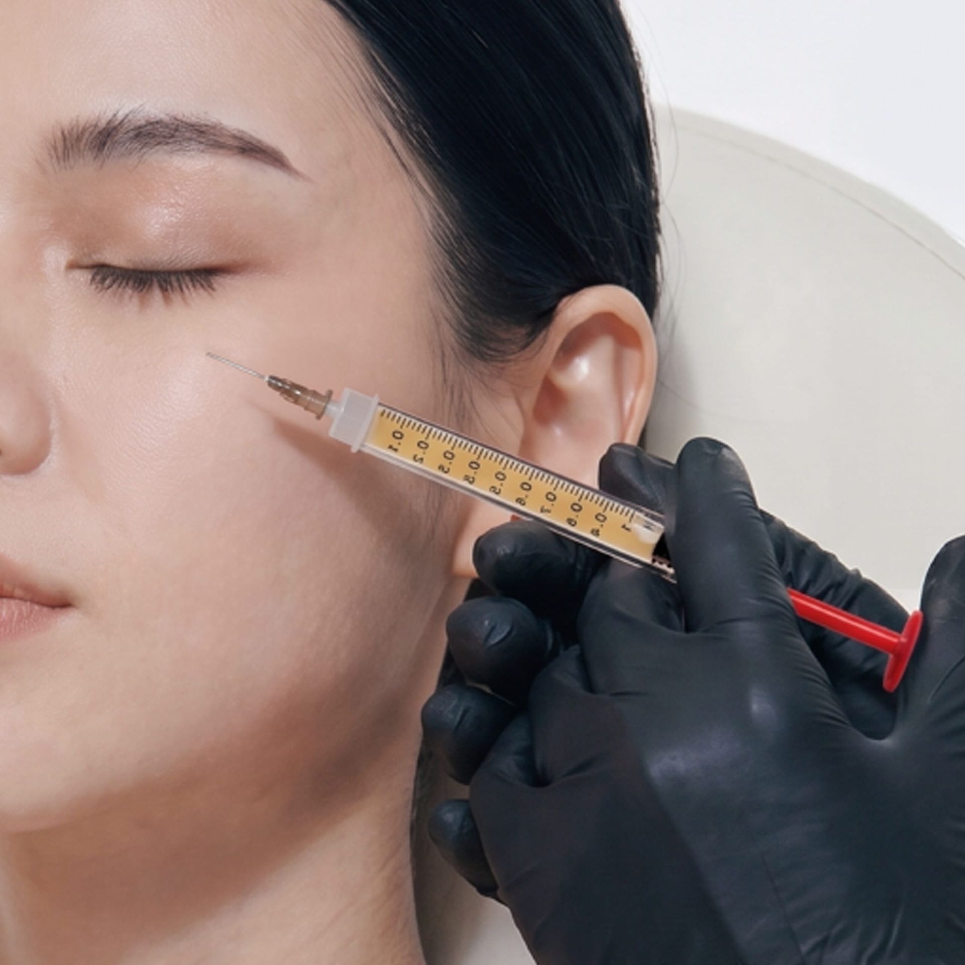 BIANCA CLINICでのezGEL施術風景。医療用グローブを着用した医師が、女性患者の頬へ精密に注入を行っている様子